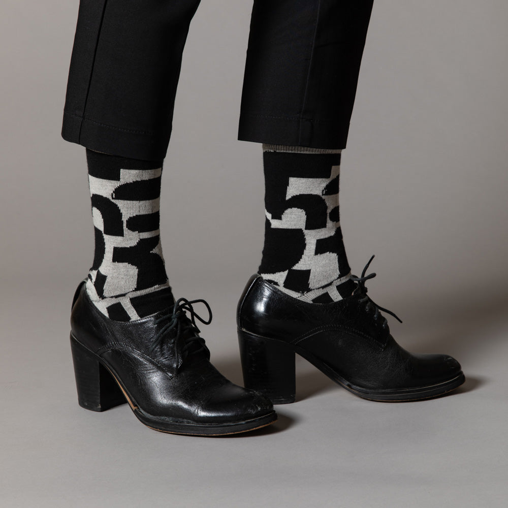 Elevate your everyday style with our elegant unisex socks designed by the KaRiniTi Studio. These monochromatic socks blend clean lines with subtle, refined details, echoing our passion for precision and typography. Perfect for any outfit, each pair brings a unique design element inspired by our studio's signature obsession with structured layouts and minimalist aesthetics.
- Numbers: Featuring bold, oversized numbers in various cuts, this design draws inspiration from KaRiniTi's signature wrapping paper. T