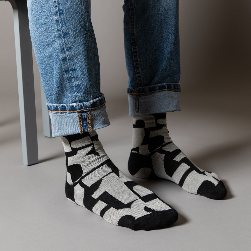 Elevate your everyday style with our elegant unisex socks designed by the KaRiniTi Studio. These monochromatic socks blend clean lines with subtle, refined details, echoing our passion for precision and typography. Perfect for any outfit, each pair brings a unique design element inspired by our studio's signature obsession with structured layouts and minimalist aesthetics.
- Numbers: Featuring bold, oversized numbers in various cuts, this design draws inspiration from KaRiniTi's signature wrapping paper. T