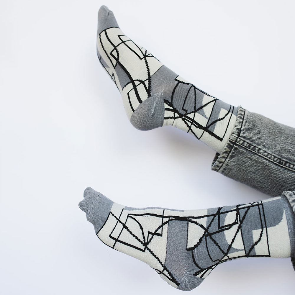 Elevate your everyday style with our elegant unisex socks designed by the KaRiniTi Studio. These monochromatic socks blend clean lines with subtle, refined details, echoing our passion for precision and typography. Perfect for any outfit, each pair brings a unique design element inspired by our studio's signature obsession with structured layouts and minimalist aesthetics.
Cutout: Inspired by our silkscreen prints, this design layers typography, numbers, and contour lines, forming a bold new composition. I