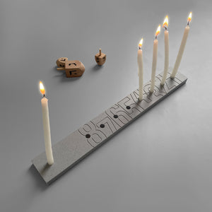 Hanukkah Menorah The minimalistic design of the classic menora, making it super easy to count the candles. 33 cm x 4.5 cm x 1 cm Corian DuPont Color: Gray --- * Candle wax easily cleaned with hot water * Packed in a cardboard box * The hue and color may vary slightly from item to item
