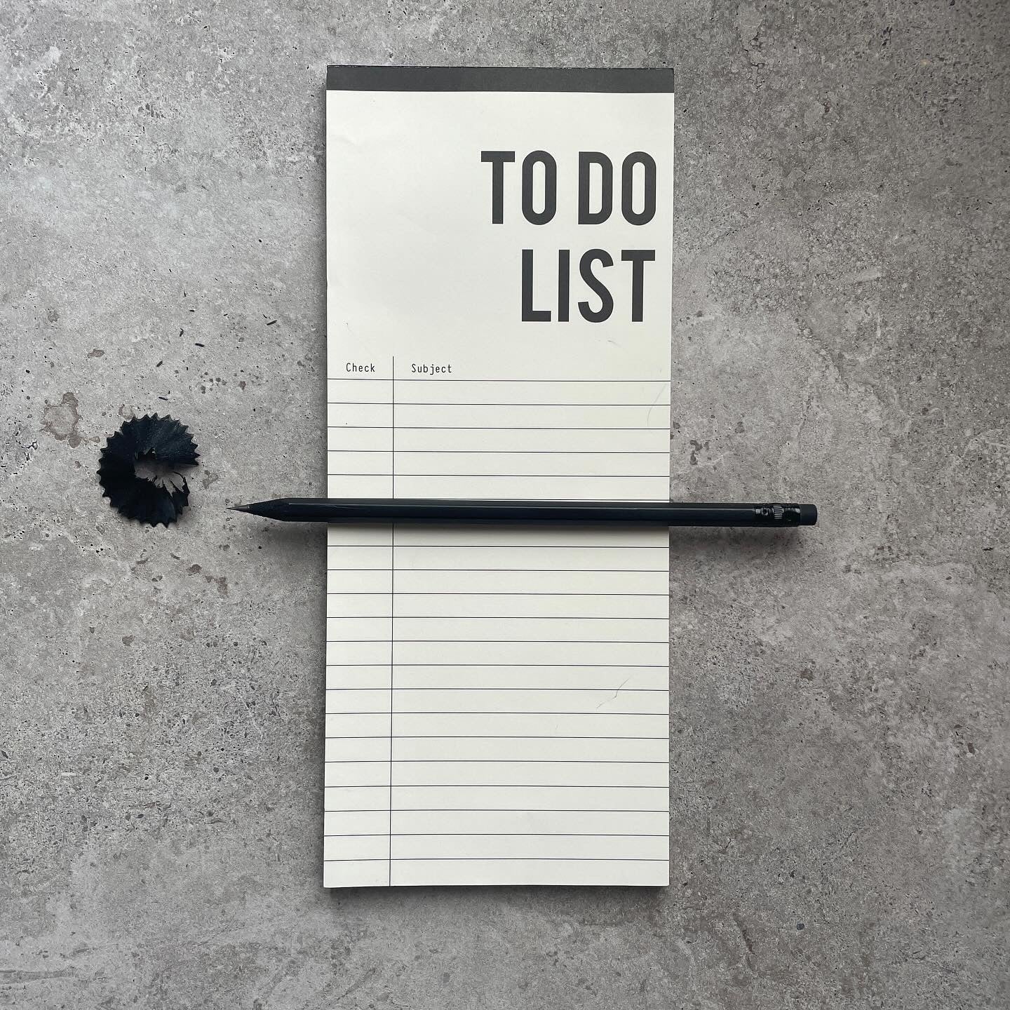 To Do List notepad on concrete with a sharpened black pencil and pencil shavings