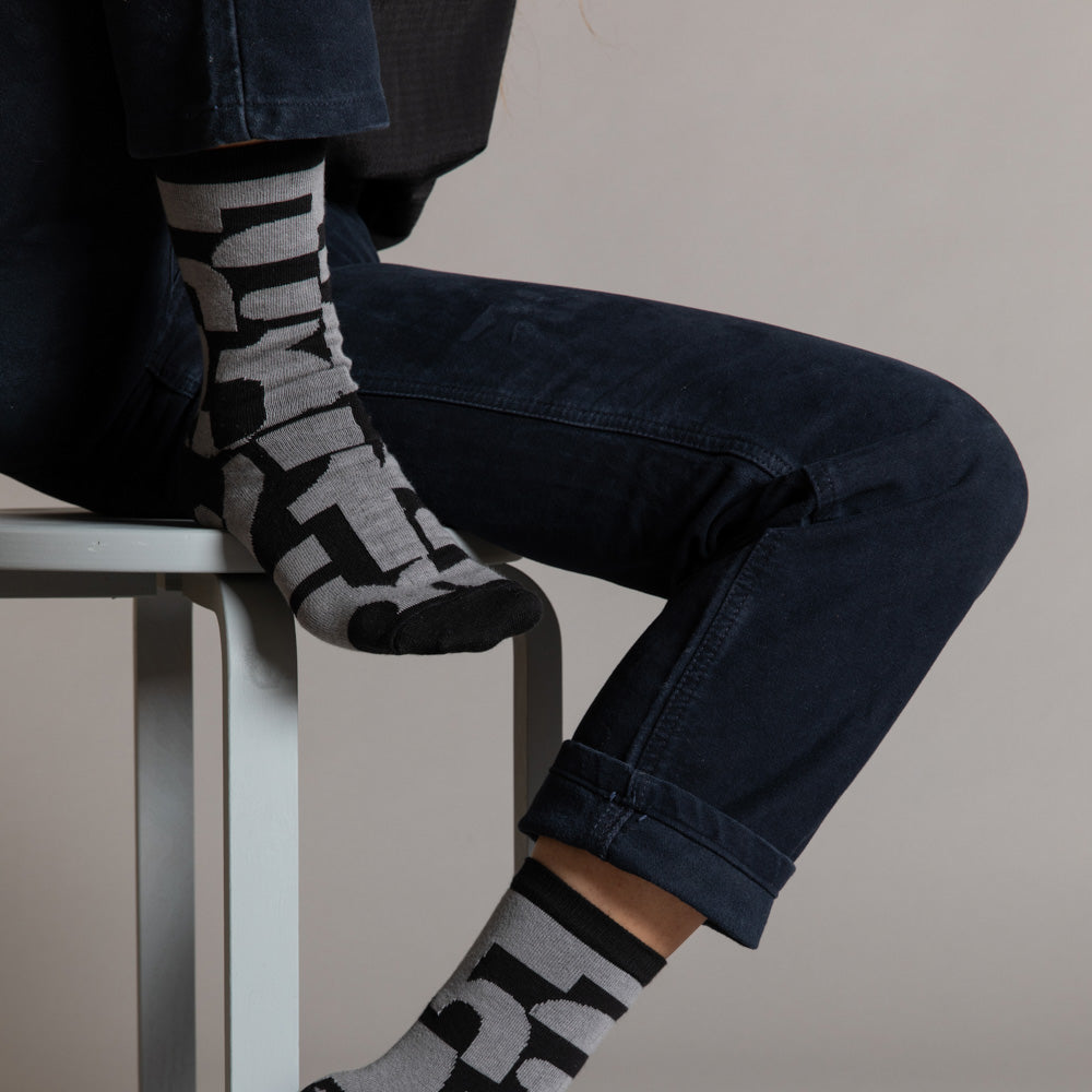 Elevate your everyday style with our elegant unisex socks designed by the KaRiniTi Studio. These monochromatic socks blend clean lines with subtle, refined details, echoing our passion for precision and typography. Perfect for any outfit, each pair brings a unique design element inspired by our studio's signature obsession with structured layouts and minimalist aesthetics.

- Numbers: Featuring bold, oversized numbers in various cuts, this design draws inspiration from KaRiniTi's signature wrapping paper. T