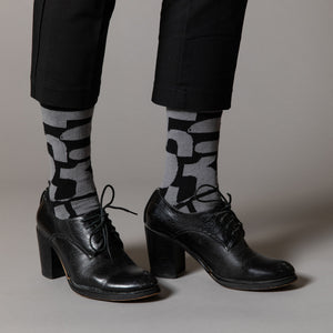 Elevate your everyday style with our elegant unisex socks designed by the KaRiniTi Studio. These monochromatic socks blend clean lines with subtle, refined details, echoing our passion for precision and typography. Perfect for any outfit, each pair brings a unique design element inspired by our studio's signature obsession with structured layouts and minimalist aesthetics.

- Numbers: Featuring bold, oversized numbers in various cuts, this design draws inspiration from KaRiniTi's signature wrapping paper. T