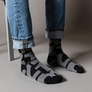 Elevate your everyday style with our elegant unisex socks designed by the KaRiniTi Studio. These monochromatic socks blend clean lines with subtle, refined details, echoing our passion for precision and typography. Perfect for any outfit, each pair brings a unique design element inspired by our studio's signature obsession with structured layouts and minimalist aesthetics.

- Numbers: Featuring bold, oversized numbers in various cuts, this design draws inspiration from KaRiniTi's signature wrapping paper. T