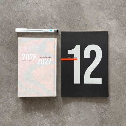 KaRiniTi Year Plan 2026/2027 – pastel-cover weekly calendar and black 12-month planner with white hexagon gel pen