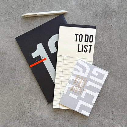 Black 12-Month Planner layered with a To Do List notepad, a Shana Tova greeting card and a white gel pen