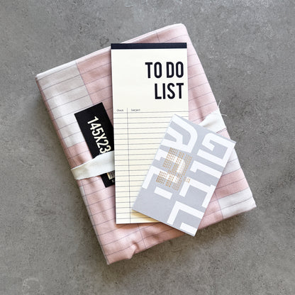 Pink KaRiniTi tablecloth with a To Do List notepad and a Shana Tova greeting card stacked on top