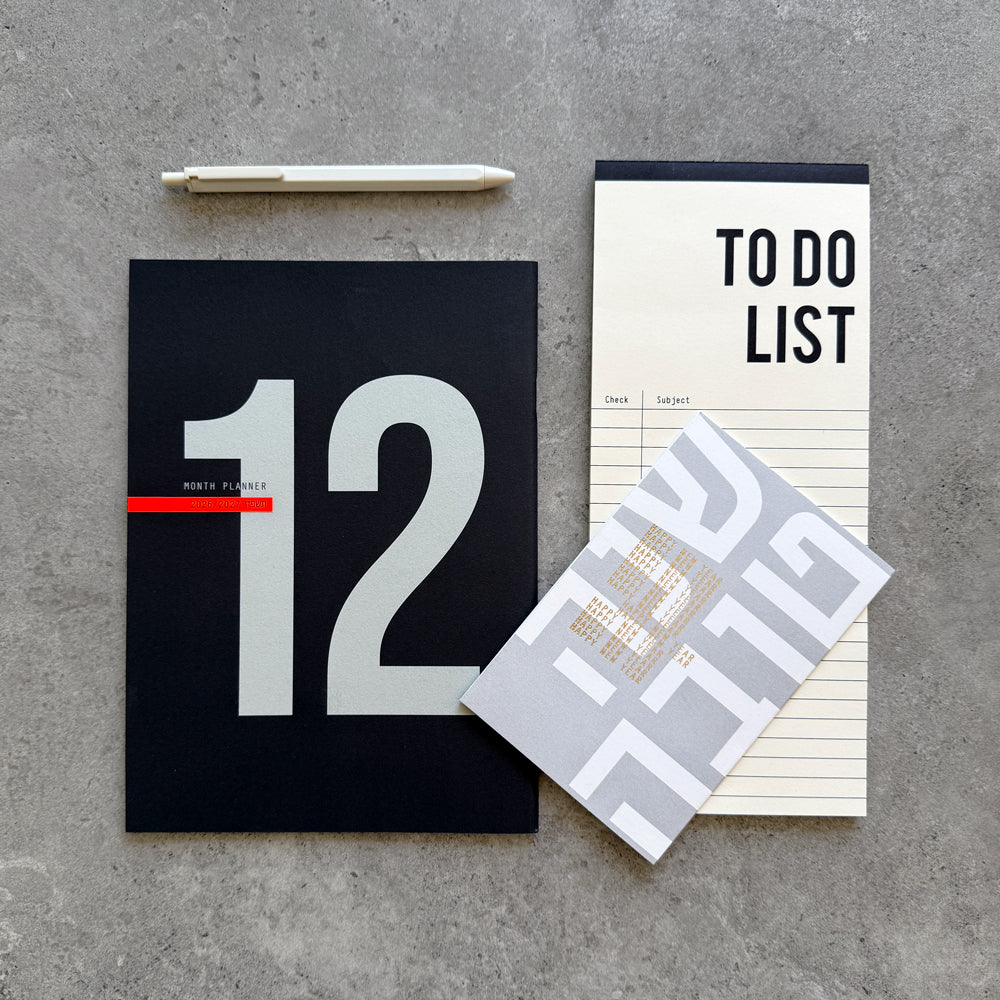 12-Month Planner with a large 12 on a black cover, a To Do List notepad, white gel pen and a Shana Tova greeting card