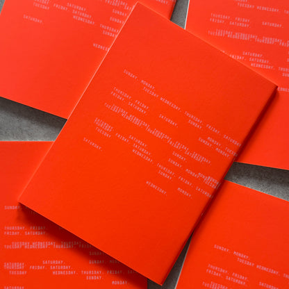 Neon orange Everyday Notebook covers printed with the days of the week