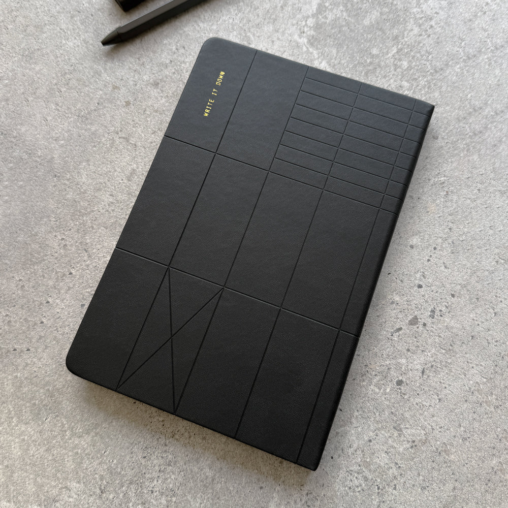 Overhead angled view of black PU hardcover notebook with geometric embossing