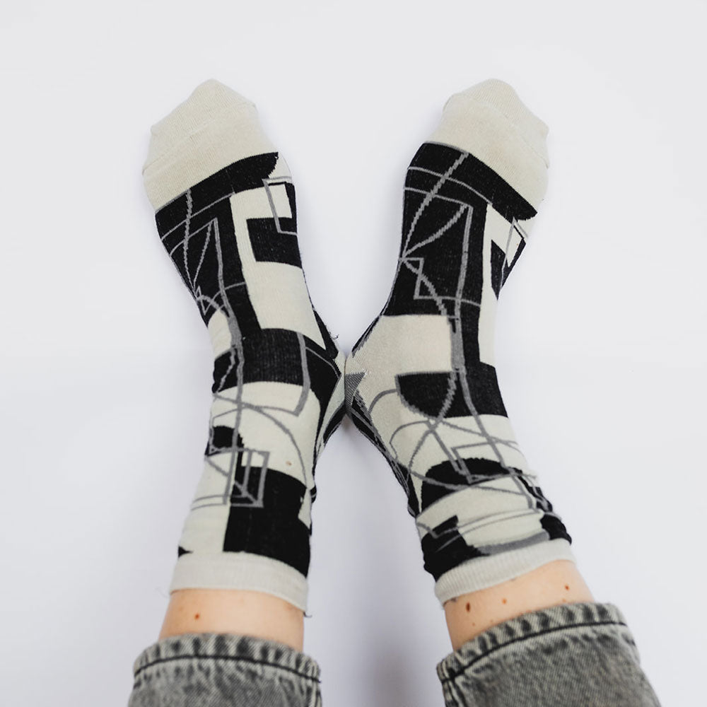 Elevate your everyday style with our elegant unisex socks designed by the KaRiniTi Studio. These monochromatic socks blend clean lines with subtle, refined details, echoing our passion for precision and typography. Perfect for any outfit, each pair brings a unique design element inspired by our studio's signature obsession with structured layouts and minimalist aesthetics.

Cutout: Inspired by our silkscreen prints, this design layers typography, numbers, and contour lines, forming a bold new composition. I