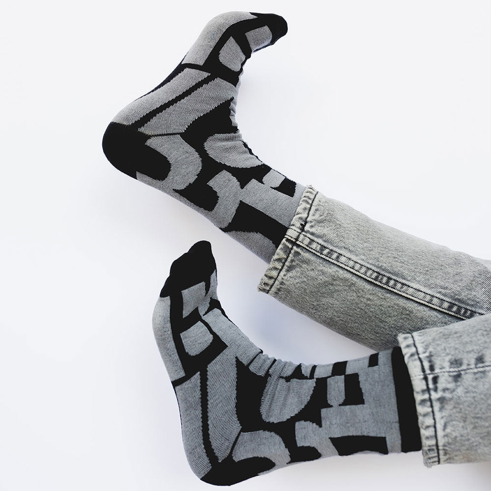 Elevate your everyday style with our elegant unisex socks designed by the KaRiniTi Studio. These monochromatic socks blend clean lines with subtle, refined details, echoing our passion for precision and typography. Perfect for any outfit, each pair brings a unique design element inspired by our studio's signature obsession with structured layouts and minimalist aesthetics.

- Numbers: Featuring bold, oversized numbers in various cuts, this design draws inspiration from KaRiniTi's signature wrapping paper. T