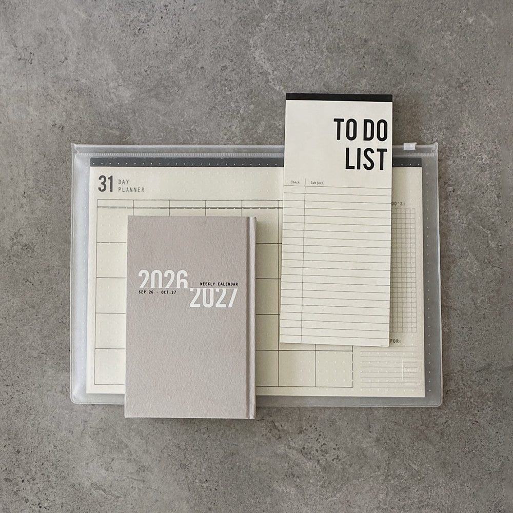 KaRiniTi Super Efficiency 2026/2027 – grey weekly calendar in front, To Do List and 31-day planner in transparent zip case