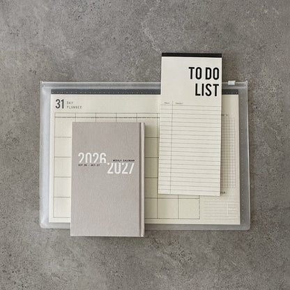 KaRiniTi Super Efficiency 2026/2027 – grey weekly calendar in front, To Do List and 31-day planner in transparent zip case