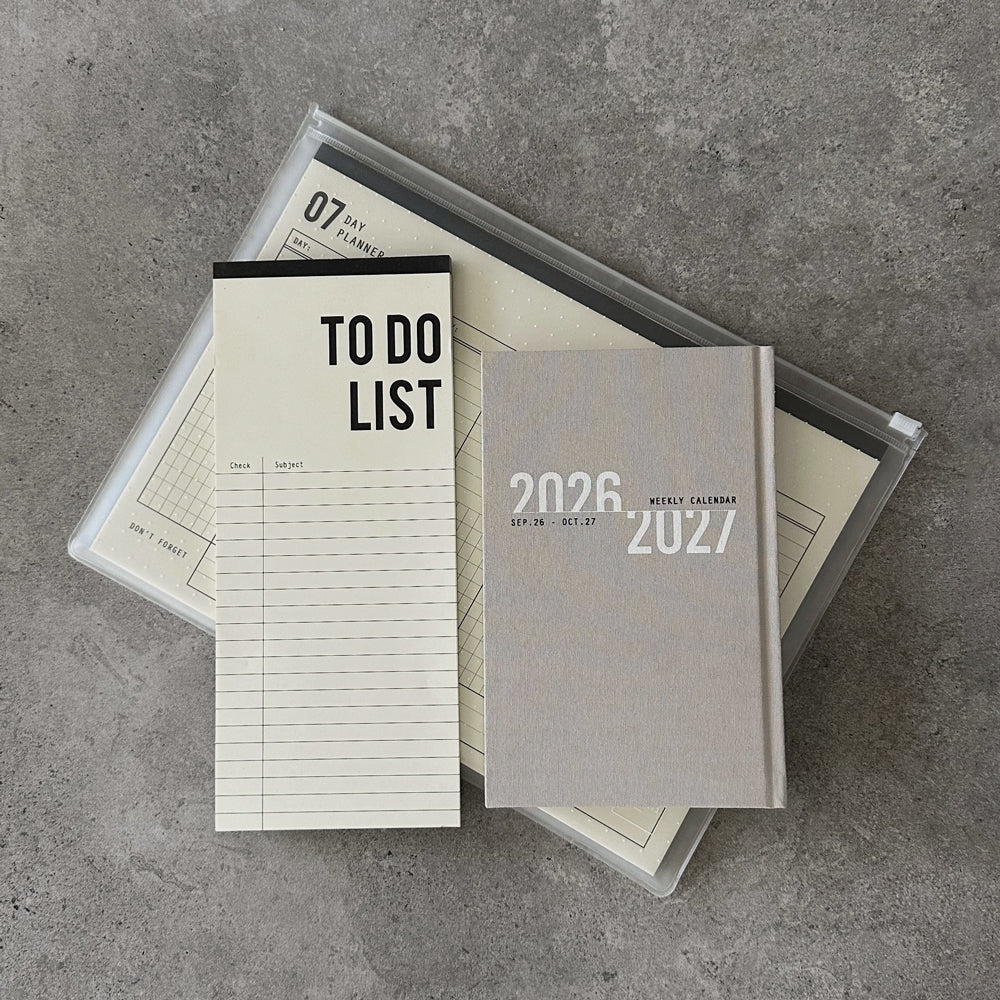 KaRiniTi Super Efficiency 2026/2027 – grey weekly calendar and To Do List atop transparent zip case with 07-day planner inside