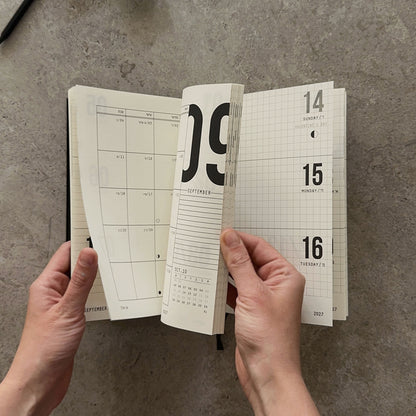 KaRiniTi Weekly Calendar 2026/2027 – hands fanning pages from September 2026 monthly spread to February 2027 weekly view