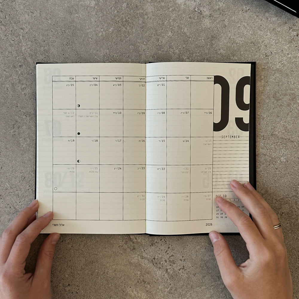 KaRiniTi Weekly Calendar 2026/2027 – grey, open to September 2026 Hebrew monthly spread, hands holding flat