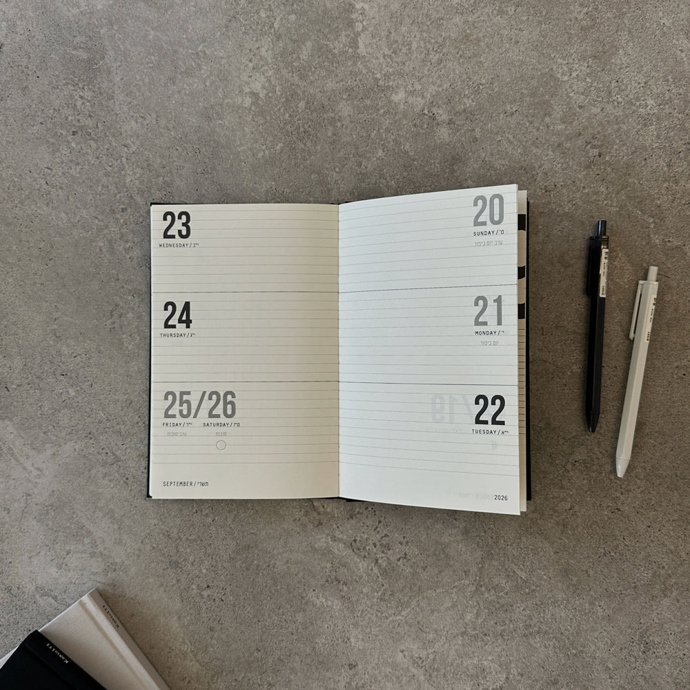 KaRiniTi Weekly Calendar 2026/2027 – grey, open to September 20–26 weekly spread with dark blue and white hexagon gel pens