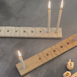 KaRiniTi - Hanukkah Menorah   The minimalistic design of the classic Menorah makes it super easy to count the candles.  33 cm x 4.5 cm x 1 cm  Ceramics  Color: Terracotta  ---  * Candle wax easily cleaned with hot water  * Packed in a cardboard box  * The hue, color, and dimensions may vary slightly from item to item