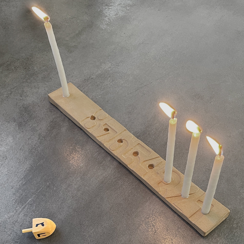 KaRiniTi - Hanukkah Menorah   The minimalistic design of the classic Menorah makes it super easy to count the candles.  33 cm x 4.5 cm x 1 cm  Ceramics  Color: Terracotta  ---  * Candle wax easily cleaned with hot water  * Packed in a cardboard box  * The hue, color, and dimensions may vary slightly from item to item